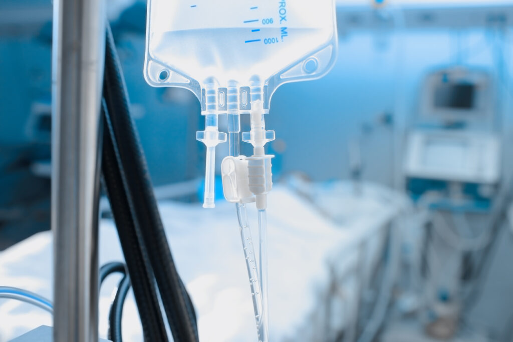 Intravenous drip on the background of patient under the heart monitoring