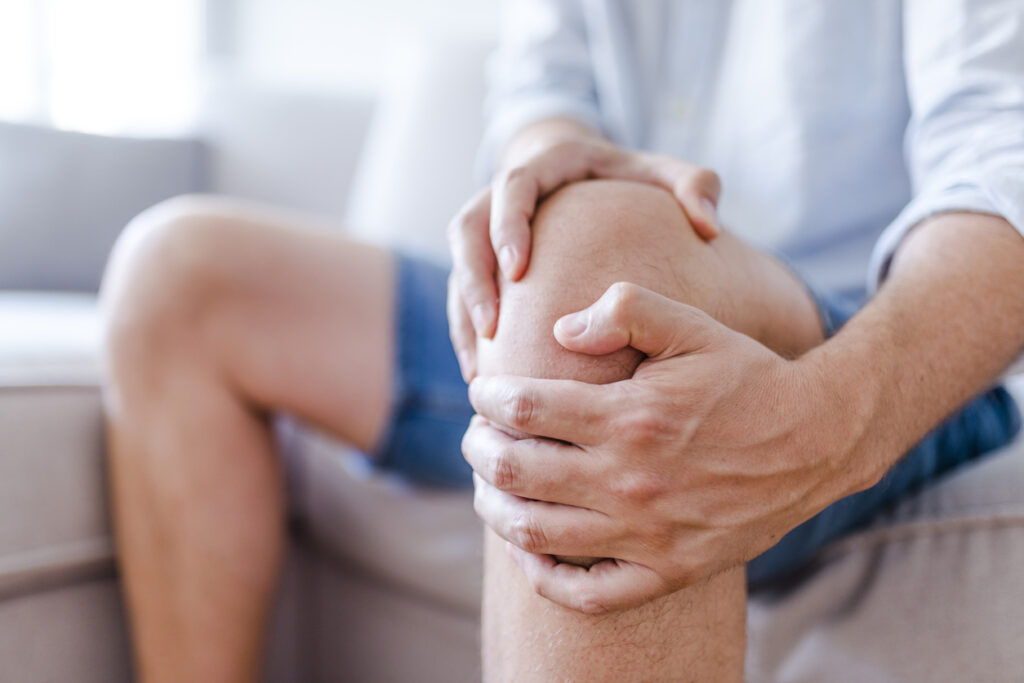 A mature man massaging his painful knee